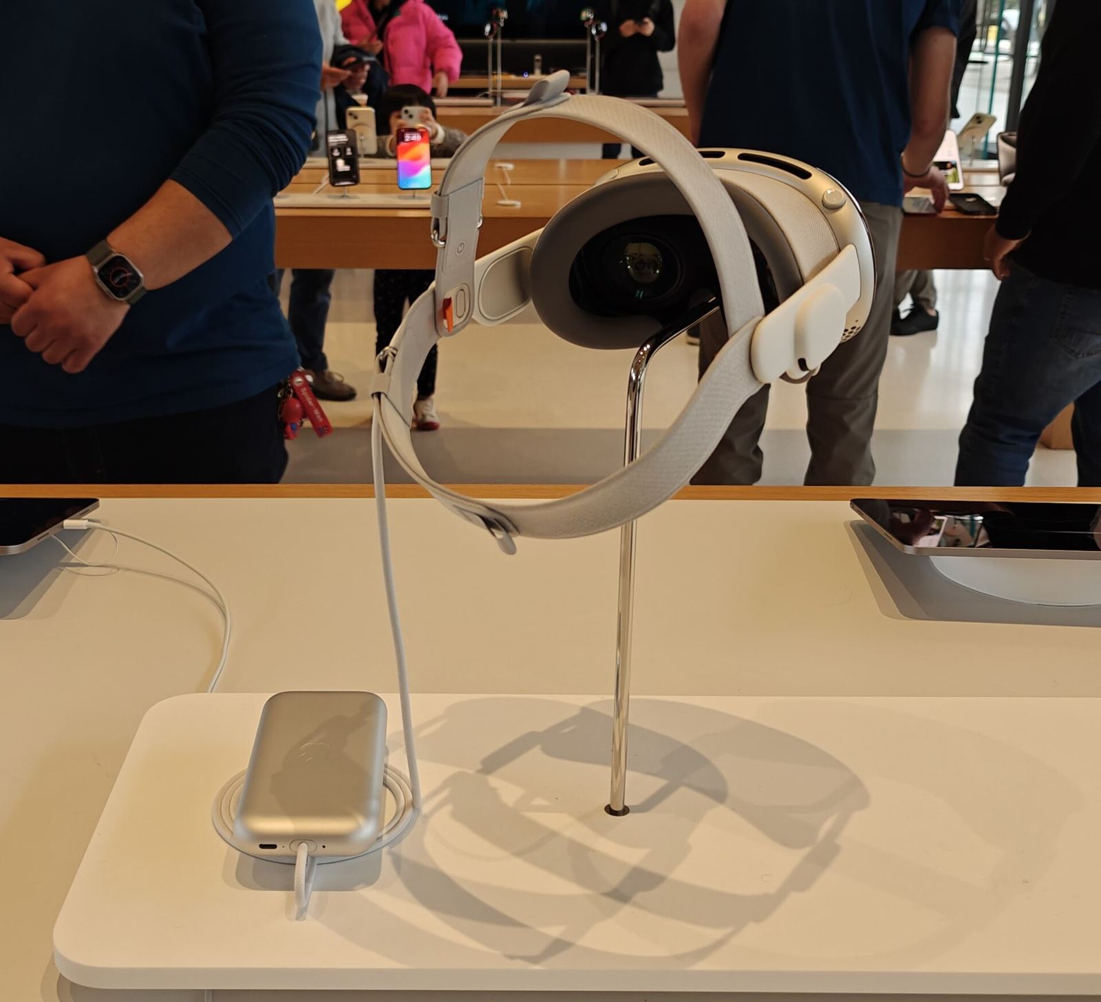 Le casque Apple Vision Pro, posé à côté de son chargeur.